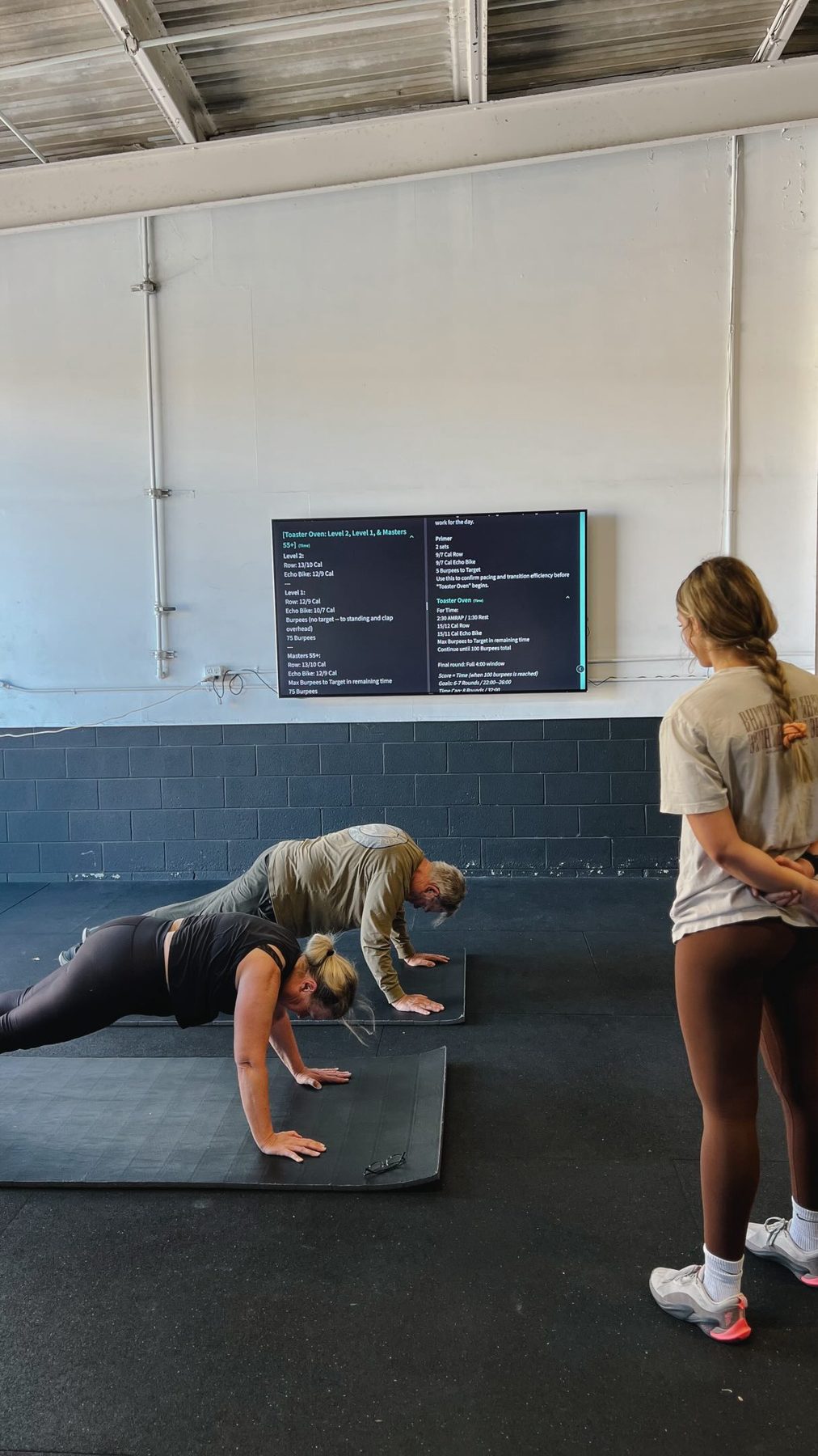 Coaches answering a member's questions at O-SEA CrossFit in San Clemente