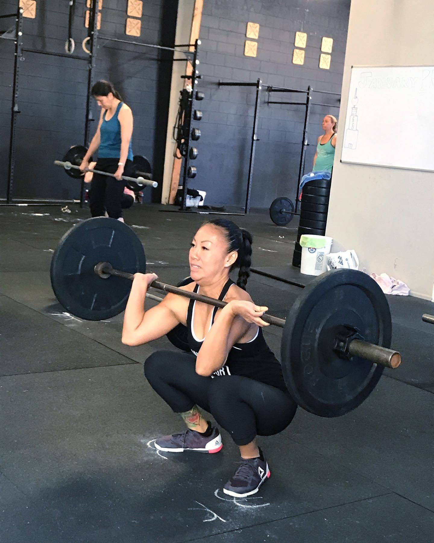 A member front squatting in a CrossFit class at O-SEA